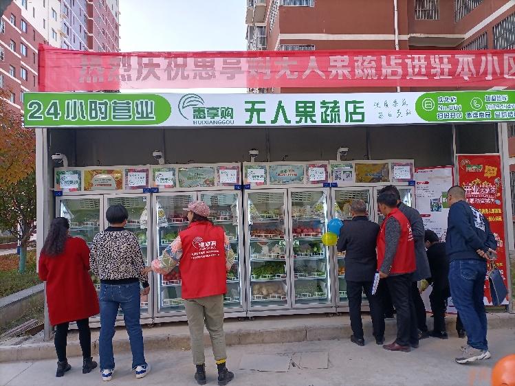 市民在庆化二区无人售货果蔬店前选购