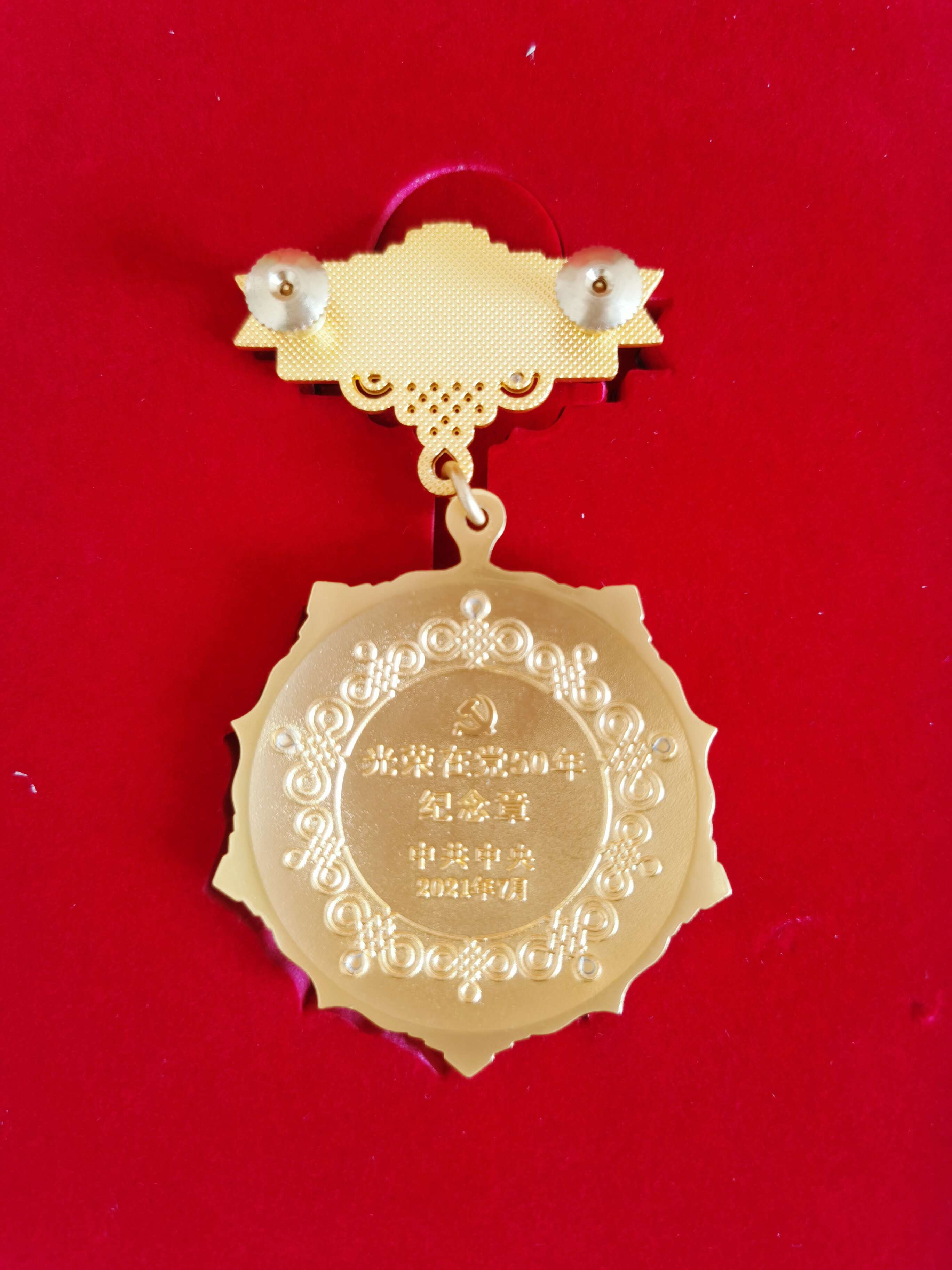 光荣在党50年纪念奖章背面。  闫慧/摄