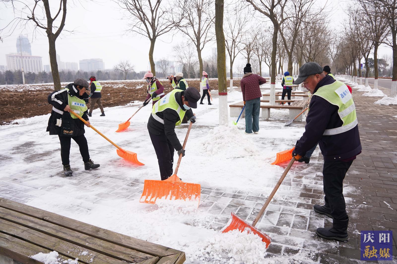 【创建文明城・庆阳在行动】庆阳市城市海绵运动绿地工作人员有序清理路面积雪积冰